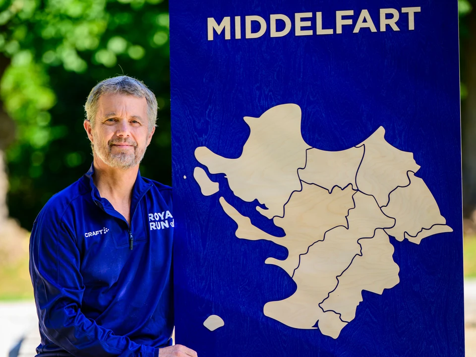 Hans Majestæt Kong Frederik med Royal Run skilt, der viser omridset af Middelfart Kommune