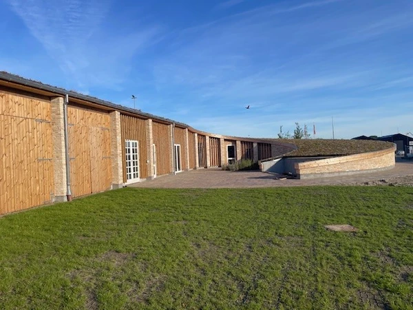 billede af det cirkulære hus, hvor der skal være byttezone. Huset er lavet af brugte mursten og træ.