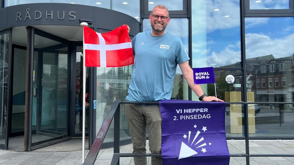 Borgmester Anders Møllegård står med flag foran Middelfart Rådhus.