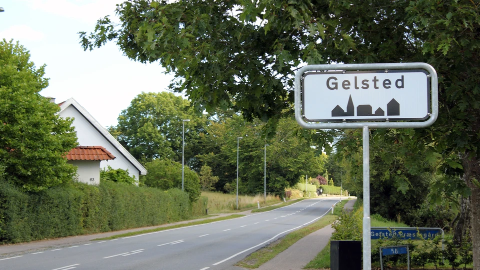 Vej omkranset af træer med Gelsted byskilt